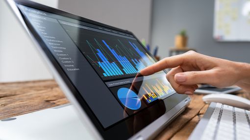 hand touching tablet with data analytics on screen